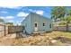 The fenced-in backyard has a small deck, a door leading to inside, and sparse grass and weeds at 523 W Hancock St, Lakeland, FL 33803