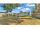Fenced backyard with a storage shed, a deck, chairs, and sparse grass and weeds at 523 W Hancock St, Lakeland, FL 33803
