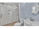 Bathroom featuring a glass-enclosed shower, round mirror, and a clean, stylish design at 523 W Hancock St, Lakeland, FL 33803