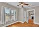 Bright bedroom with hardwood floors, a ceiling fan, neutral paint, and a view of the neighborhood at 523 W Hancock St, Lakeland, FL 33803