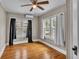 Sunlit bedroom with hardwood floors, two windows with different curtains, and a mini-split air conditioner at 523 W Hancock St, Lakeland, FL 33803