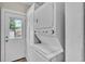 A bright laundry area with stackable washer/dryer and a door to the outside at 523 W Hancock St, Lakeland, FL 33803