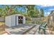 Outdoor shed with an open door, organized shelving, an adjacent deck, and chairs nearby at 523 W Hancock St, Lakeland, FL 33803