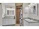 Dual sink bathroom with tiled shower, white cabinets, framed mirrors, and modern lighting at 5246 Montserrat Dr, Lakeland, FL 33812
