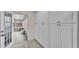 Hallway features storage cabinets, tile flooring, and entry to a sun room with screened windows at 5246 Montserrat Dr, Lakeland, FL 33812