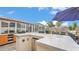 Outdoor kitchen including a bar with seating, a granite counter, a built in refrigerator, and access to the pool at 5246 Montserrat Dr, Lakeland, FL 33812