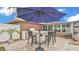 Outdoor kitchen featuring a bar with seating, built in grill, refrigerator, and granite counter, all set under a patio umbrella at 5246 Montserrat Dr, Lakeland, FL 33812