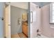 Renovated bathroom with pink tiled shower, safety bars and sink with granite countertops at 525 Eagle Run, Lakeland, FL 33809