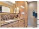 Bathroom featuring granite countertops, wood cabinets, and decorative mirror at 525 Eagle Run, Lakeland, FL 33809