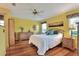 Bright bedroom features wood floors, ceiling fan and decorative wall art for a comfortable ambiance at 525 Eagle Run, Lakeland, FL 33809