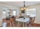 Cozy dining room featuring natural lighting, hardwood floors, a dining table with six chairs, and a view to the living room at 525 Eagle Run, Lakeland, FL 33809