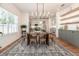 Well-lit dining room with modern chandelier, hardwood floors, and view of the kitchen at 527 W Park St, Lakeland, FL 33803