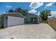 Charming home with a detached garage and a brick driveway under a bright blue sky with white clouds at 527 W Park St, Lakeland, FL 33803