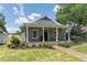 Charming home featuring a well-manicured lawn, brick walkway, and inviting front porch with stately columns at 527 W Park St, Lakeland, FL 33803