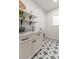 Bright laundry room featuring star-patterned tile floors, white cabinets and floating shelves at 527 W Park St, Lakeland, FL 33803