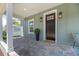Charming front porch with a brick floor, dark front door and decorative lanterns flanking each side at 527 W Park St, Lakeland, FL 33803