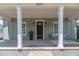 Charming front porch features brick flooring, stately columns, and cozy seating area at 527 W Park St, Lakeland, FL 33803