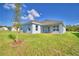 Spacious backyard with lush green grass and a view of the home's rear exterior and patio at 580 Jett Ln, Davenport, FL 33837