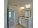 Modern bathroom featuring a double sink vanity, tile floor, and open doorway to main bedroom at 580 Jett Ln, Davenport, FL 33837