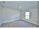 Carpeted bedroom featuring a window with natural light and neutral decor at 580 Jett Ln, Davenport, FL 33837