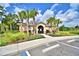 Community clubhouse featuring a stylish design, lush landscaping, and palm tree accents at 580 Jett Ln, Davenport, FL 33837