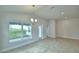 Bright dining area featuring tile flooring, a modern chandelier, and a large window overlooking the backyard at 580 Jett Ln, Davenport, FL 33837