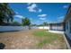 Expansive backyard features a white fence, mature trees, and a covered patio area at 603 Reflections Loop, Winter Haven, FL 33884