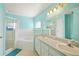 Bright bathroom featuring double sinks, a large mirror, a soaking tub, and a separate glass-enclosed shower at 603 Reflections Loop, Winter Haven, FL 33884