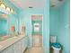 Fresh bathroom with light blue walls, white vanity, and doorway to an adjacent bedroom at 603 Reflections Loop, Winter Haven, FL 33884