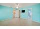 Bright bedroom with blue walls, ceiling fan, and open doorways to kitchen and bathroom at 603 Reflections Loop, Winter Haven, FL 33884