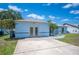 Side view of light blue single-story home featuring a well-maintained driveway and lush lawn, under a bright blue sky at 603 Reflections Loop, Winter Haven, FL 33884