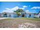 Inviting single-story home with a blue exterior, a well-manicured lawn, and a quaint palm tree in the front yard at 603 Reflections Loop, Winter Haven, FL 33884