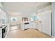 Well-lit kitchen featuring white cabinets, modern appliances, and a functional layout, seamlessly connected to the dining area at 603 Reflections Loop, Winter Haven, FL 33884