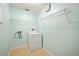 Clean laundry room with a white dryer, overhead shelving and pale green walls at 603 Reflections Loop, Winter Haven, FL 33884