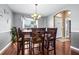 Dining room with wooden table and chairs, decorative chandelier, and large window with natural light at 633 Heather Glen Loop, Winter Haven, FL 33884