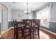 Elegant dining room with stylish chandelier, wooden table and chairs, and bright window view at 633 Heather Glen Loop, Winter Haven, FL 33884
