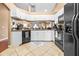 Bright kitchen with white cabinets, black appliances, breakfast bar, tile floor and pass through to living room at 633 Heather Glen Loop, Winter Haven, FL 33884