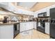 Well-lit kitchen with white cabinets, modern appliances, breakfast bar, and neutral tile flooring at 633 Heather Glen Loop, Winter Haven, FL 33884