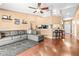 Open-concept living room with hardwood floors, stylish gray sectional sofa, and adjacent kitchen with bar seating at 633 Heather Glen Loop, Winter Haven, FL 33884
