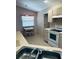 Cozy kitchen area featuring an adjacent dining table, light-toned cabinets, and a tiled backsplash at 668 Jamaica Cir, Lakeland, FL 33803