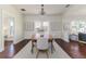 Light-filled dining room with stylish chandelier, wood table, and three windows at 737 Johnson Ave, Lakeland, FL 33801