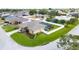 Aerial view of a well-maintained home with lush landscaping, a sparkling pool, and a fenced backyard, ready for move-in at 7890 Ashford Dr, Lakeland, FL 33810