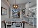 Dining area with a wood table and white chairs, under a modern chandelier, offers views of the screened-in pool area at 7890 Ashford Dr, Lakeland, FL 33810