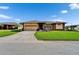Charming single-story home with a well-manicured lawn, mature landscaping, and a two-car garage at 7890 Ashford Dr, Lakeland, FL 33810