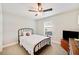 Cozy bedroom with a metal bed frame, ceiling fan, and window with blinds at 807 Osceola St, Lakeland, FL 33801