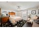 A lovely bedroom with a black floral rug, upholstered chair, and a beautifully carved wooden headboard at 807 Osceola St, Lakeland, FL 33801