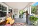 Inviting porch with egg chair, grey wood deck, and decorative accents and plants at 807 Osceola St, Lakeland, FL 33801