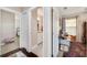 Bright hallway leading to the bathroom featuring white doors and wood and tile flooring at 807 Osceola St, Lakeland, FL 33801