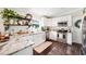 Charming kitchen boasts white cabinetry, stainless steel appliances, and granite countertops with wood flooring at 807 Osceola St, Lakeland, FL 33801