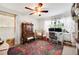 Home office with colorful floral rug, ceiling fan, desk with computer, and armoire at 807 Osceola St, Lakeland, FL 33801